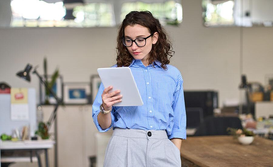 A small business owner reviews her email marketing metrics on a tablet 