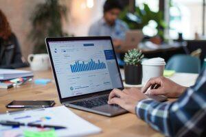 Small business owner reviewing CRM dashboard and contact data on laptop