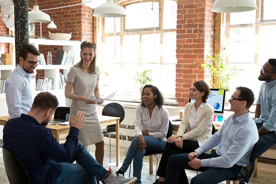 A happy, diverse small business team meets in the office