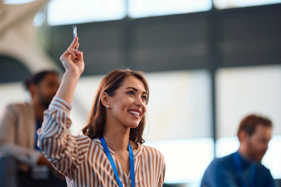 A young, female entrepreneur asks a question at a business conference