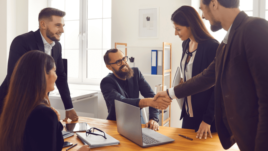 colleagues shaking hands in office