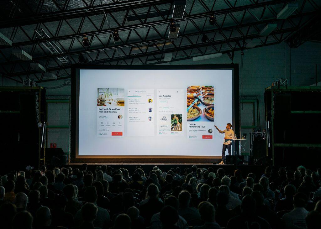 a man standing in front of a large screen similar to presentations at networking events in Chicago